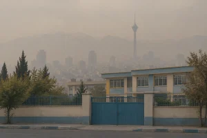 نمای ساختمان مدرسه و افق مه‌آلود تهران در روزهای آلودگی هوا و احتمال تعطیلی مدارس